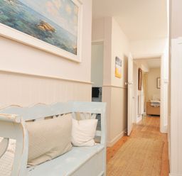 A hallway with a bench and a painting at Sandy Lodge Rock