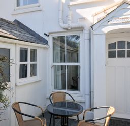 An outdoor area with a table and chairs at Coppingers Cottage in Polzeath