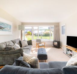 A living room with a sofa and television at Windyhill in Polzeath