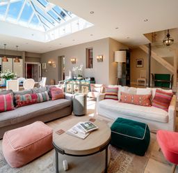 A living room with sofas and poufs under a skylight at Trevanion in Rock