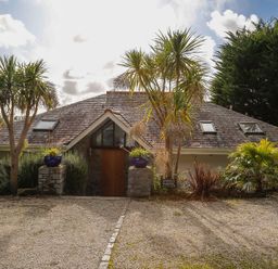 A house with a sloped roof surrounded by trees and plants at Camel Point in Rock