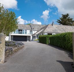 A driveway leading to a house with a garage gate and bushes at Landers Field in Rock