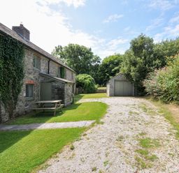 An outdoor space with a house and garage at Orchard Cottage in Polzeath