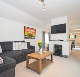A living room with a sofa and coffee table at Orchard Cottage in Polzeath