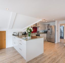 A kitchen with a countertop island with flowers and appliances at Upper Deck Rock