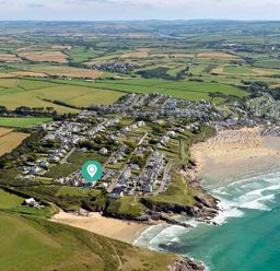 An aerial view of a coastal town with houses fields and beaches at Egloskerry in New Polzeath