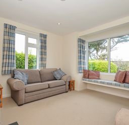 A living room with a sofa and a window at Hillcroft Bungalow Daymer Bay