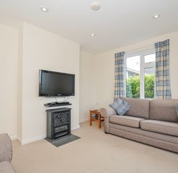 A living room with a television and a fireplace at Hillcroft Bungalow Daymer Bay