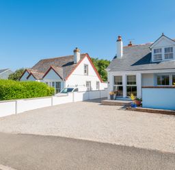 Two white houses with grey slate roofs and gravel driveways with potted plants at Number 28 in Port Isaac