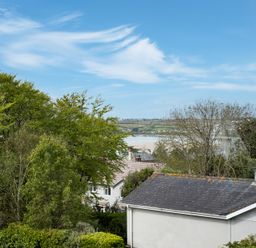 A view of trees houses a body of water and hills in the background at Flaad House in Rock