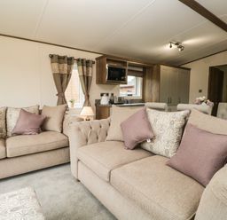 A living room with beige sofas and patterned cushions at Ashton Lodge - Sherwood 4 South Lakeland Leisure Village