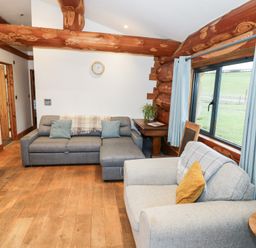 A living room with sofas and a coffee table at Cedar Cabin at Salford Court Farm Fishing Cabins near Clifton Upon Teme