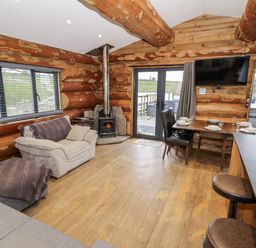 A living room with a sofa and dining table at Douglas Cabin at Salford Court Farm Fishing Cabins near Clifton Upon Teme