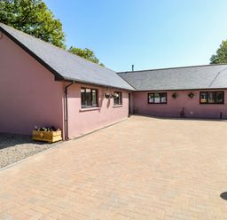 A single-story house with pink exterior walls and a paved driveway at 1 The Warren Robeston Wathen near Narberth