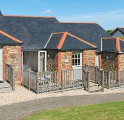 Stone cottages with slate roofs and wooden railing on a gravel path at 5 Keeper's Cottage Hillfield Dartmouth