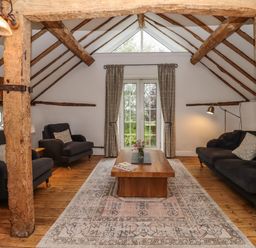 A sitting room with wooden beams two sofas a wooden coffee table and glass doors at 1 White House Cottages Bromsash near Lea