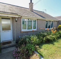 An outdoor view of a house with a front door and garden at 7 Bro Branwen Aberffraw near Rhosneigr