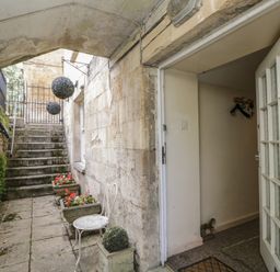 An outdoor entrance area with stairs and flower pots at Dollar Ward House Basement Cirencester