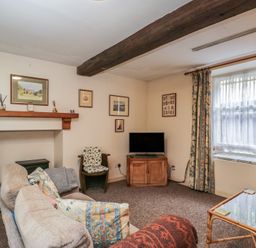A living room with a sofa and television at Dollar Ward House Basement Cirencester