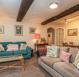 A living room with sofas and a table at Dollar Ward House Basement Cirencester