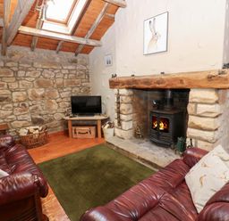 A living room with a fireplace and television at The Granary in Rothbury