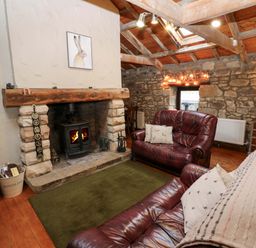 A living room with a fireplace and sofas at The Granary in Rothbury