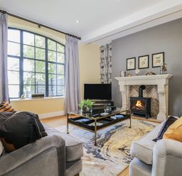A living room with sofas a coffee table a fireplace and a large window at Tarn End Cottages 5 Talkin near Brampton Cumbria
