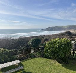 An outdoor view of the ocean and hillside at Stonecroft in Praa Sands
