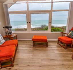 A living room with chairs and a telescope at Stonecroft in Praa Sands