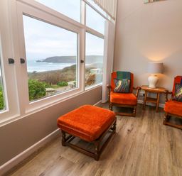 A sitting room with chairs and a lamp at Stonecroft in Praa Sands