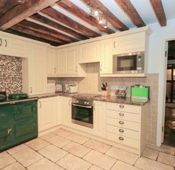 A kitchen with cabinets and a green oven at Butlers Cottage in Burford