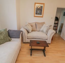 A living room with two beige sofas a small wooden coffee table and a framed picture on the wall at Sea Change Newholm near Whitby