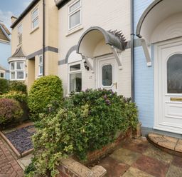 Exterior view of terraced houses with white doors and covered entrance at Little Tern Brewers Quay Harbour