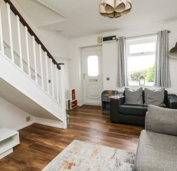A living room with two sofas a side table and a staircase at Little Tern Brewers Quay Harbour