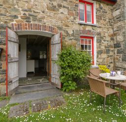 An outdoor seating area with a table and chairs at Sycamore Vestry in Pontfaen near Fishguard