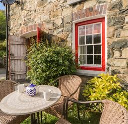 An outdoor seating area with table and chairs at Sycamore Vestry Pontfaen near Fishguard