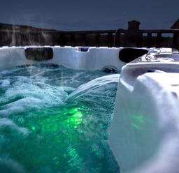A bubbling hot tub with water jets and green underwater lights outside at Chi Prenn Byhan in Tintagel