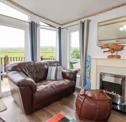 A living room with a sofa and fireplace at Orchard View in Bossiney near Tintagel
