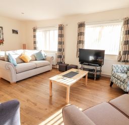 A living room with sofas a television and a wooden coffee table at Awel Y Berwyn in Llangynog