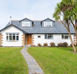 A house with a stone path leading to a wooden door and trees on the lawn at Silverdale in Rock