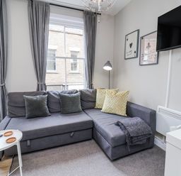 A living room with a sectional sofa and a television at 24 Baxtergate, Whitby