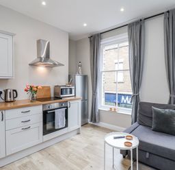 A kitchen with cabinets, countertop, and sofa at 24 Baxtergate in Whitby
