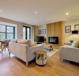A living room with a sofa, chairs, coffee table and television at Riverside Park 3 in Keswick