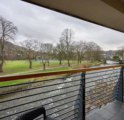 A balcony view of a river and trees at Riverside Park 5 in Keswick