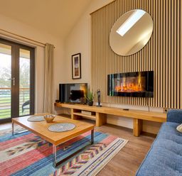 A living room with a television and sofa at Riverside Park 5 in Keswick