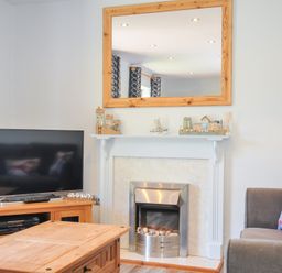 A living room with a television and coffee table at Columbine Cottage in Bude