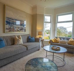 A sitting room with sofas and large windows at Argoed in Abersoch