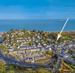 An aerial view of a coastal village with houses boats and a harbor at The Coach House in Abersoch