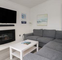 A living room with a sofa and television at The Warren D7 in Abersoch