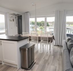 A kitchen with dining area and sofa at The Warren D7 Abersoch